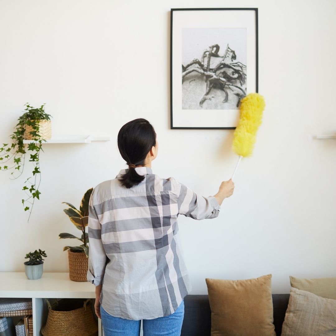 Woman dusting a picture